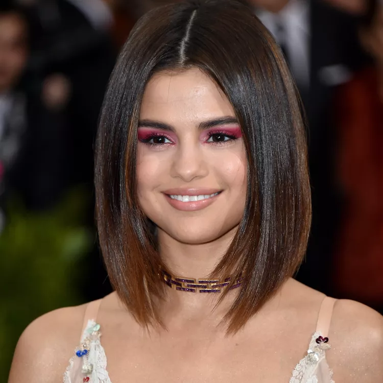 Selena Gomez in round long bob features soft, loose waves that add movement and volume to the style. 
