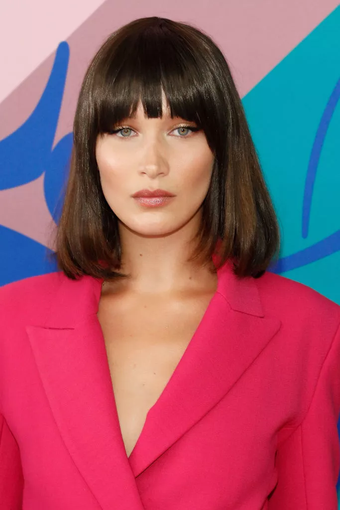 The oval '80s-inspired blown-out bob is typically cut to chin or jaw length and features a voluminous and blown-out texture. This hairstyle is characterized by its bouncy and voluminous look, which is achieved by using a round brush and a hairdryer to create volume and movement. 