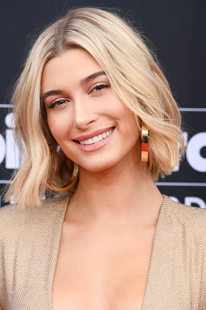 mid-length layered bob features choppy layers that add movement and volume to the style. The length of the bob hits just above the shoulder, which helps to elongate the face and balance out the angles of the square face shape. 
