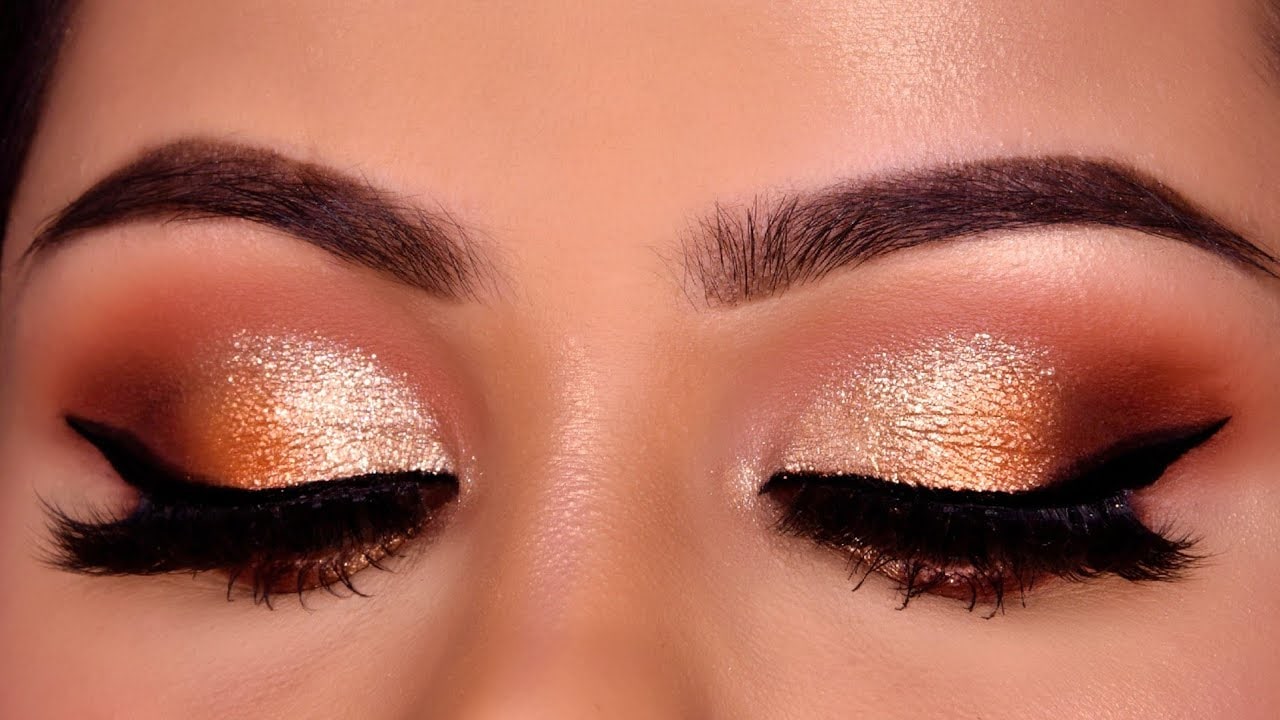 With a fluffy blending brush, I apply a rich bronze shadow, blending back and forth for an even layer. Using a dark brown, I sweep the outer crease, blending for desired drama. Adding shimmery gold on the inner two-thirds with my fingers, I achieve an elegant "Smokey eye makeup" look.